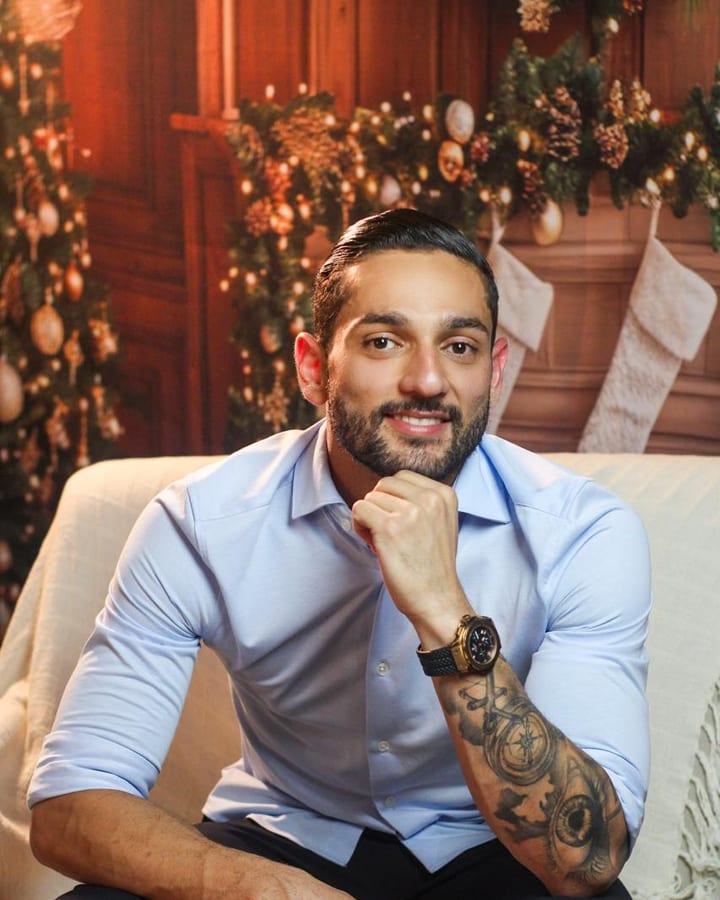 Dr. Saulo Silva sorrindo, sentado, com a mão no queixo